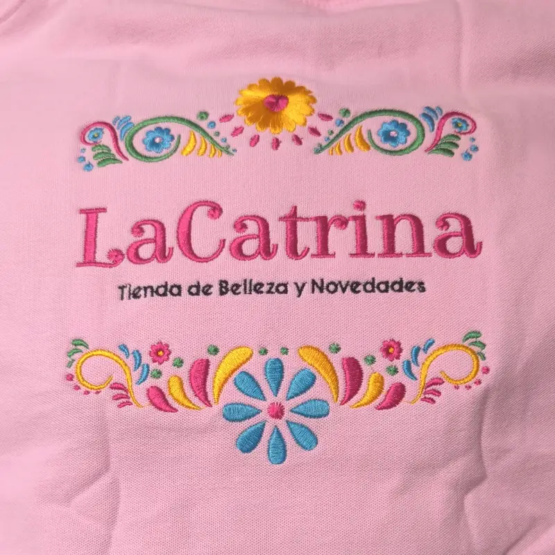 Bordado a color con motivos florales sobre un polo rosa